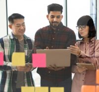 Team collaboration brainstorming with sticky notes and laptop